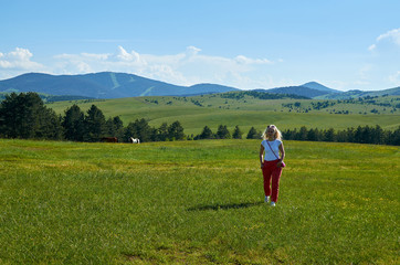 Fototapeta na wymiar Woman walking in a wonderful mountain landscape in spring