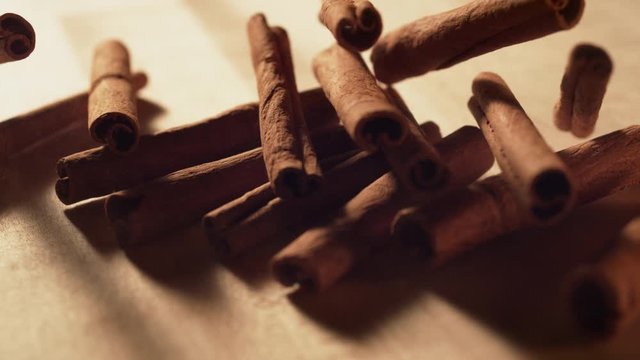 Cinnamon sticks falling on a table. Slow Motion. 