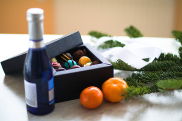 new year presents on the table. blue bottle of champagne, candys and mandarin