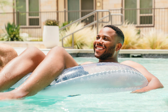 Happy man relaxing in pool float
