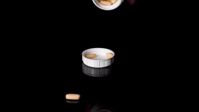 Prescription Drug Pills Being Poured into a Container Cap, Slow Motion