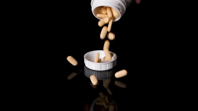 Prescription Drug Container Pouring Pills into a Cap, Slow Motion
