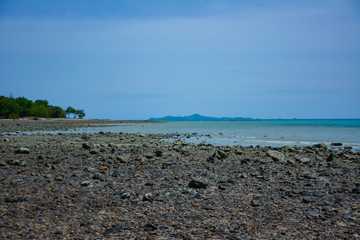 Stone courtyard on the public beach,Beautiful seascape with natural stone yard on beach against cloudy sky,Rocky shore at the seacoast with seascape and blue sky,