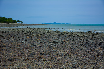 Stone courtyard on the public beach,Beautiful seascape with natural stone yard on beach against cloudy sky,Rocky shore at the seacoast with seascape and blue sky,