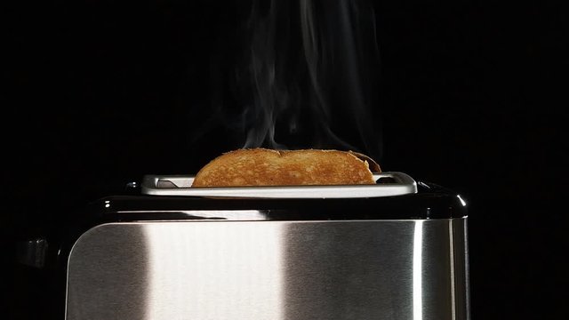 Video of a steel toaster making hot toast for breakfast.
