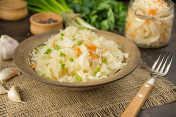 Sauerkraut with carrots in a bowl. Homemade food. Sour food. Pickled vegetables. Vegetarian vegan food. Side view .