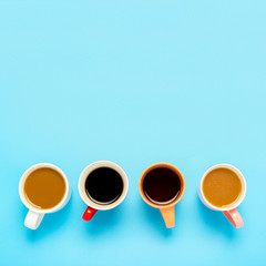 Cups with hot drinks, coffee, cappuccino, coffee with milk on a blue background. Concept coffee shop, meeting friends, breakfast with friends, friendly team. Square. Flat lay, top view