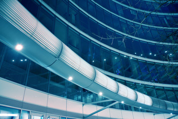 Night architecture - building with glass facade. Modern building in  business district. Concept of economics, financial. Photo of commercial office building exterior. Abstract image of office building