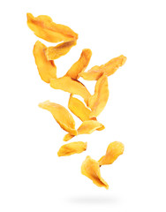 Dried chopped mango slices falling down on a white background