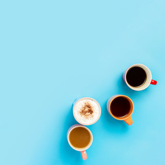 Cups with hot drinks, coffee, cappuccino, coffee with milk on a blue background. Concept coffee...
