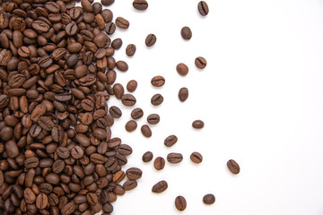 fresh roasted coffee beans sprinkled on a white background