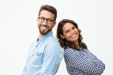 Content man and woman standing back to back. Side view of cheerful young couple standing together...