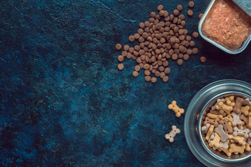 Wet and dry pet food. Cat or dog pate on old table. Top view.
