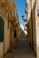 one of the charming, narrow street in Ortigia, oldest part of the beautiful baroque city of Syracuse in Sicily, Italy