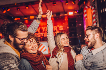 Group of friends at outdoor winter party, music concert, dancing