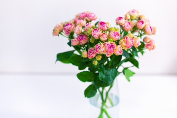 Bouquet of pink spray peony roses in vase.