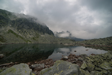 mountain lake mirror reflection looking at the mountains stracajuce in the clouds