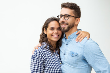 Happy young couple standing and embracing. Beautiful cheerful young couple hugging and smiling at...