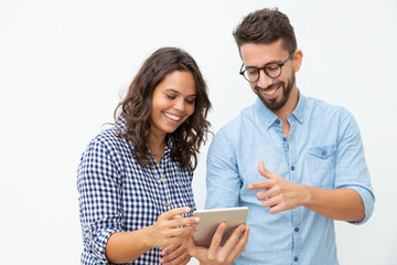 Smiling couple using tablet pc. Cheerful young man and woman standing together and using digital...