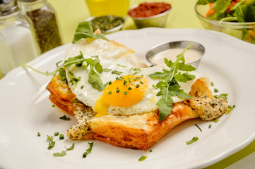 Delicious breakfast. Toast with egg, salad and spices on a green background