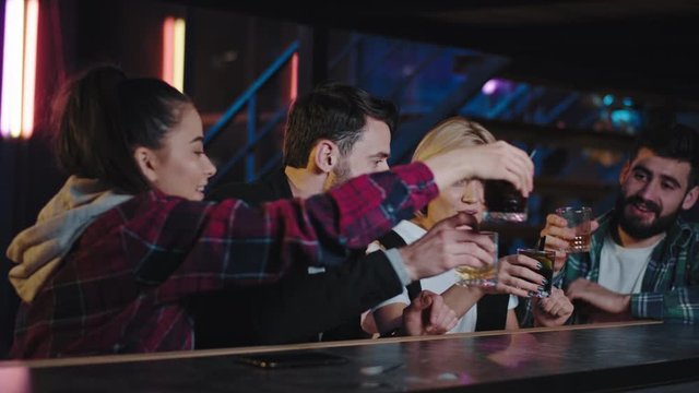 Happy and excited friends in a bar shaking hands they waiting for the drinks get the drinks and start to enjoy the night together smiling they feeling so excited