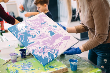 Young people are fond of drawing. Acrylic paint flows over the canvas. chaotic drawing.