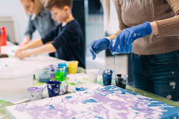 People of all ages are fond of drawing. Acrylic paint flows over the canvas. chaotic drawing.