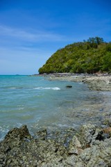 Beautiful rock beach with sea ocean and mountain blue sky landscape background,An island in the sea with beaches, rocks and turquoise water in the hot summer sun of Thailand.