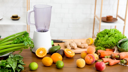 Blender jar and fresh fruits and vegetables on table at home