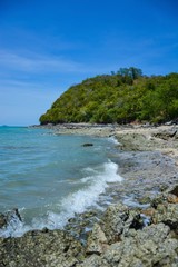 Fototapeta na wymiar Beautiful rock beach with sea ocean and mountain blue sky landscape background,An island in the sea with beaches, rocks and turquoise water in the hot summer sun of Thailand.