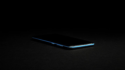 Blue phone on the black background. Blue smartphone. 