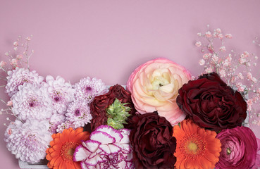 Colorful flower arrangement on pink pastel background. Top view with copy space. Mother's day, valentines, birthday and women's day concept