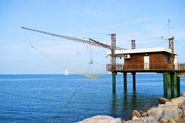 Fototapeta premium caratteristiche capanne da pesca sul molo di Porto Garibaldi nel Mare Adriatico nel comune di Comacchio in provincia di Ferrara in Italia