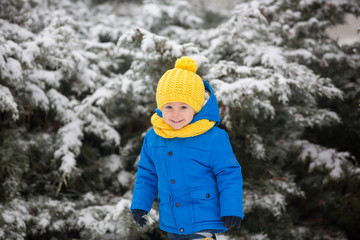 Fototapeta na wymiar Sweet toddler boy, playing with snow on playground
