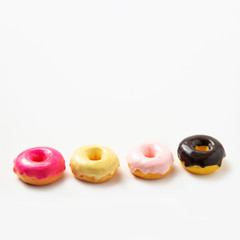 Several multi-colored donuts with chocolate icing on a white background. Copy space. Dessert. High-calorie food. National Doughnut Day, Sweetest Day. 