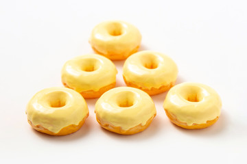 Group of donuts with yellow icing on a white background. High-calorie food.Dessert. National Doughnut Day, Sweetest Day.