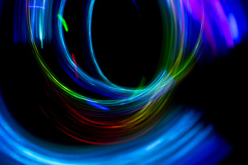 Abstract color pattern of luminous stripes on a black background, bright and smooth color streaks