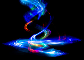 Abstract color pattern of luminous stripes on a black background, bright and smooth color streaks