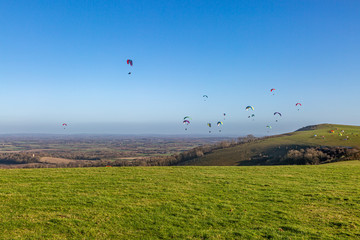 Paragliders in the sky over Firle Beacon in the South Downs, on a sunny winters day