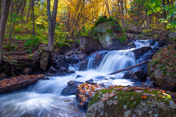 Fototapeta na wymiar Waterfall in a Laurentian forest with fall colours, Quebec