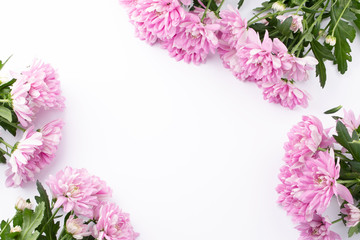 Pink flowers on white table. Top view. Space for text.
