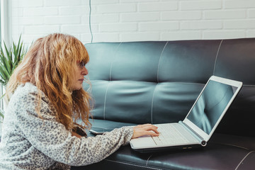 adult woman with laptop on the sofa at home