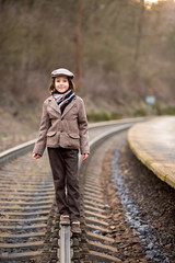 Fototapeta premium Adorable boy on a railway station, waiting for the train