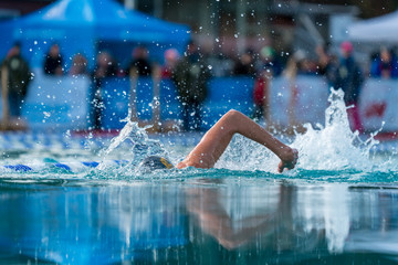 Woman swimming in an outdoor pool at an ice swim competition