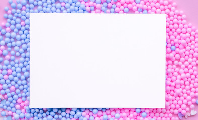 A sheet of white paper on a background of decorative balls in blue and pink