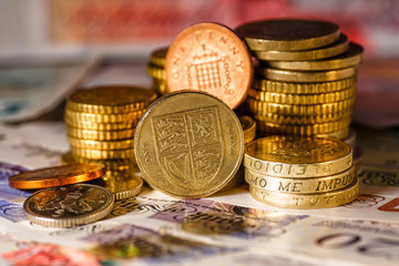British Pound Coins against a background of British assorted bank notes,Business concept
