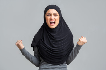 Furious islamic lady in hijab emotionally screaming, very angry to someone