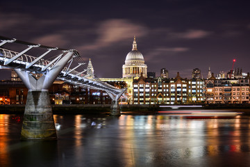 Fototapeta na wymiar Beautiful night view of the illuminated dome of St Paul's Cathedral in the City of London, London, UK, with the River Thames and the modern Millennium Bridge