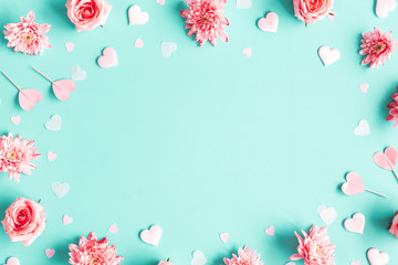 Valentine's Day background. Pink flowers, hearts on pastel blue background. Valentines day concept. Flat lay, top view, copy space