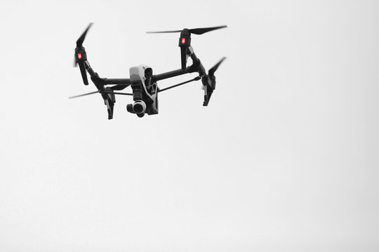 Flying drone with camera on cloudy sky 